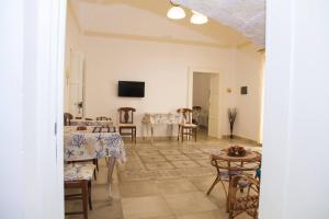 a living room with tables and chairs and a television at Le Tenute di Agnese in Felline