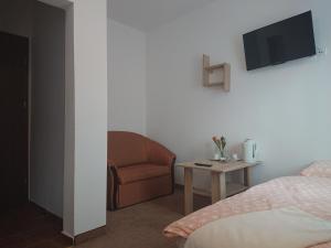 a bedroom with a bed and a chair and a tv at DW Bukówka in Karpacz
