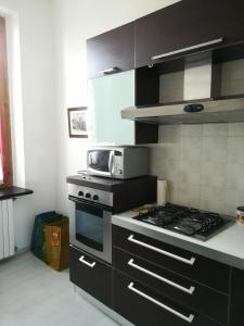 eine Küche mit einem Herd und einer Mikrowelle in der Unterkunft Milano Via Ripamonti IEO in Mailand