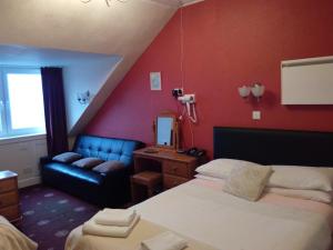 une chambre d'hôtel avec un lit et un canapé dans l'établissement Palace Hotel - Small Hotel, à Oban