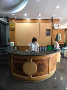 a woman standing at a bar in a lobby at Shiah Yih Hotel in Huwei