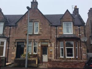 ein altes Backsteinhaus mit weißer Tür in der Unterkunft Rosebank Guest House in Inverness