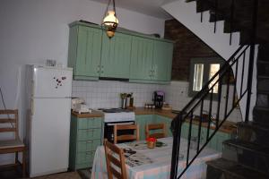 a kitchen with green cabinets and a white refrigerator at Sea View Stone Residence in Episkopión +31 photos