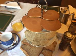 a table with three plates of bread and glasses of orange juice at Rosebank Guest House in Inverness