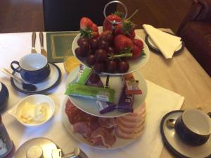 einen Teller mit Lebensmitteln mit Erdbeeren und Früchten auf dem Tisch in der Unterkunft Rosebank Guest House in Inverness