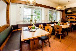 a restaurant with tables and chairs and windows at Hotel-Restaurant Bauer-Keller in Greding