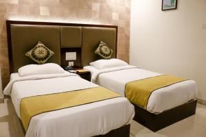 ein Hotelzimmer mit 2 Betten in einem Zimmer in der Unterkunft Hotel Winsar Park in Visakhapatnam
