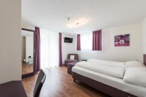 um quarto com uma cama e um sofá num quarto em Hotel Engel em Emmetten