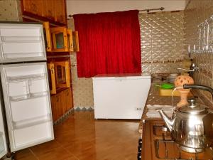 a kitchen with a white refrigerator and a red window at Dar ezzitouna in Oualidia