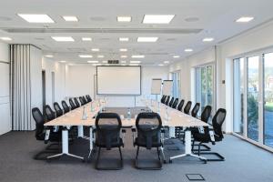 uma grande sala de conferências com uma mesa longa e cadeiras em BURGHOF - DAS HOTEL em Brombachtal