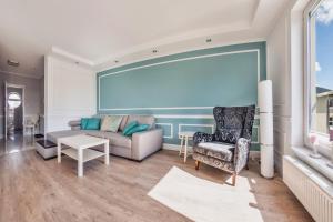 a living room with a couch and a chair at Hel Żeromskiego, Sun & Snow in Hel