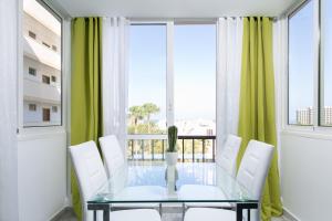 een eetkamer met een glazen tafel en witte stoelen bij 408 Enchanting El Dorado Accommodation, Sea View! in Playa de las Americas