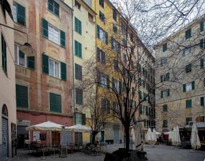 a group of buildings with tables and umbrellas in a courtyard at Lavagna Uno in Genoa