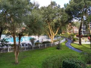 a view of a park with trees and a fence at Albertine appt 112 in Moliets-et-Maa