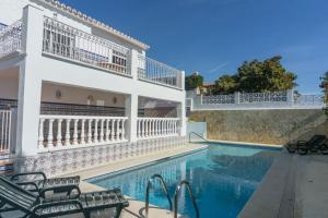 - une piscine à côté d'un bâtiment avec une maison dans l'établissement Cubo's Villa Marieli Chilches, à Xilxes