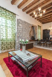 sala de estar con mesa y pared de piedra en Old Palace Apartment, en Dubrovnik