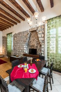 comedor con mesa, sillas y pared de piedra en Old Palace Apartment, en Dubrovnik
