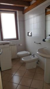 a bathroom with a sink and a toilet and a window at A due passi dalla spiaggia in Colico