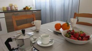 een tafel met een kom aardbeien en een kom sinaasappels bij Appartamento Spiaggia Playa in Castellammare del Golfo