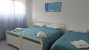 two twin beds in a bedroom with towels on them at Appartamento Spiaggia Playa in Castellammare del Golfo