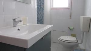 a white bathroom with a sink and a toilet at Appartamento Spiaggia Playa in Castellammare del Golfo +82 photos