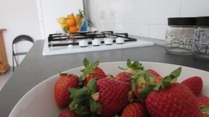 a plate of strawberries on a kitchen counter at Appartamento Spiaggia Playa in Castellammare del Golfo