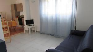 a living room with a couch and a television at Appartamento Spiaggia Playa in Castellammare del Golfo