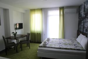 a bedroom with a bed and a table and a window at SAPA Studios & Apartments in Niš