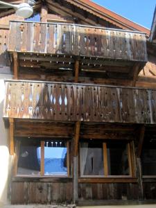 - un bâtiment en bois avec deux fenêtres et un balcon dans l'établissement Chasa Engadina, à Sent