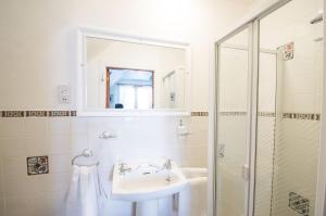 a white bathroom with a sink and a shower at Anchorage B&B in Cockenzie