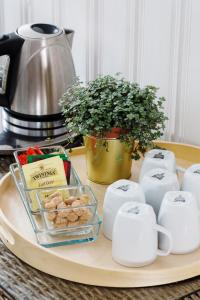 a tray with cookies and coffee cups and a plant at Pilegrimsgården Hotell og Gjestegård in Trondheim