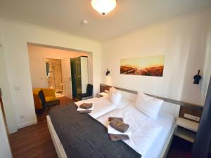 ein Schlafzimmer mit einem großen weißen Bett in einem Zimmer in der Unterkunft Ferienwohnung "Sonnendeck" Binz in Binz