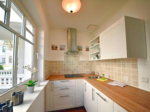 eine Küche mit weißen Schränken und einem großen Fenster in der Unterkunft Ferienwohnung "Sonnendeck" Binz in Binz
