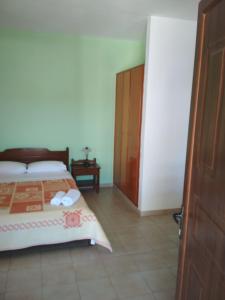 1 dormitorio con 1 cama y puerta de madera en Flamingo Apartments, en Palaikastro