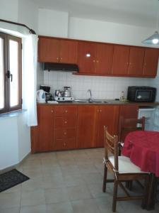 una cocina con armarios de madera y una mesa con un mantel rojo. en Flamingo Apartments, en Palaikastro
