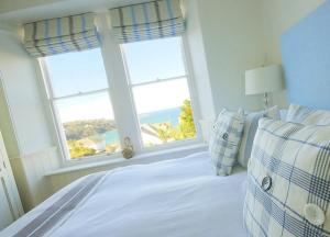 a bedroom with a bed with a view of the ocean at Headland House Luxury B&B in St Ives