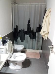 a bathroom with a toilet and a shower curtain at Bikini Apartament in Punta del Este