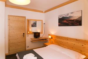 een slaapkamer met een bed met een houten hoofdeinde bij Sport Hotel Prodongo in Brallo di Pregola