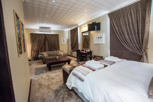 a hotel room with a large bed and a living room at Border Hotel in Jan Kempdorp