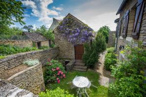 an old stone house with a garden and a table at Chez annie et jean michel Bagatelle chambres d hôtes in Châteauneuf