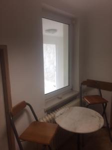 Zimmer mit 2 Stühlen, einem Tisch und einem Fenster in der Unterkunft D&E Rooms in Schwechat