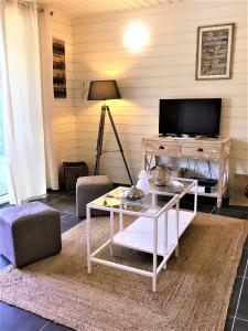 a living room with a table and a tv at Studio La Voile Blanche in Orient Bay French St Martin