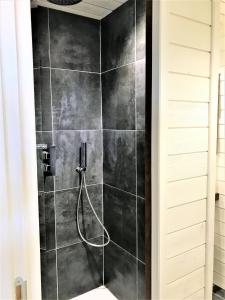 a bathroom with a shower with black tiles at Studio La Voile Blanche in Orient Bay French St Martin