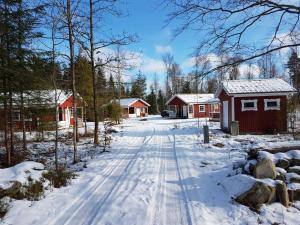 Lönashult的住宿－Hunnebo，一条有房子和雪覆盖的道路