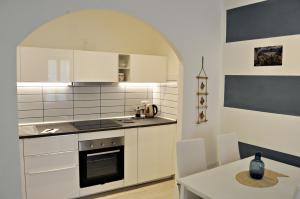 una cucina con armadi bianchi, tavolo bianco e tavolo da pranzo di Nibea Suite a Manarola