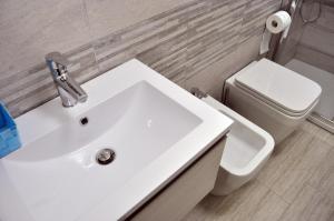 bagno con lavandino bianco e servizi igienici di Nibea Suite a Manarola Altre 24 foto
