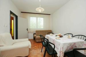 a dining room with a table and chairs and a couch at Mia Apartman in Murter +37 photos