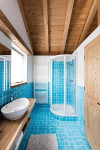 y baño azul con lavabo y ducha. en CHALET D'ERT, en La Valle