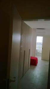 una puerta abierta a una habitación con sofá rojo en Casina degli Oleandri, en Lido Marini