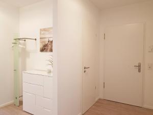 a white room with a closet and a door at Fischers Friend in Heiligenhafen +11 photos